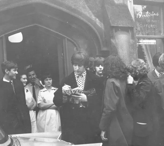 Framed Print : John Lennon, with Ringo Starr behind him, signs an autograph for a Beatles fan outside