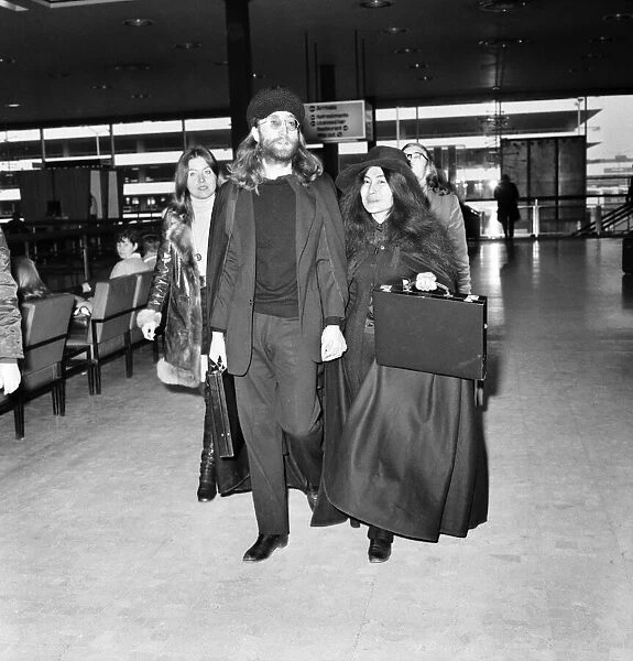 John Lennon and Yoko Ono dressed all in black, pictured at Heathrow today as they leave