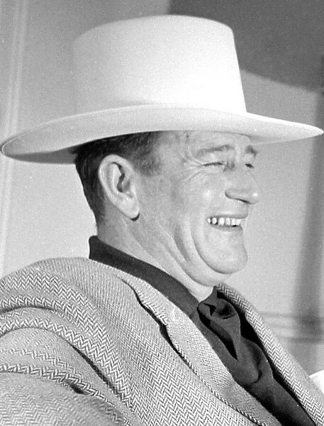 John Wayne, American film actor, arrives in London for the opening of his film '