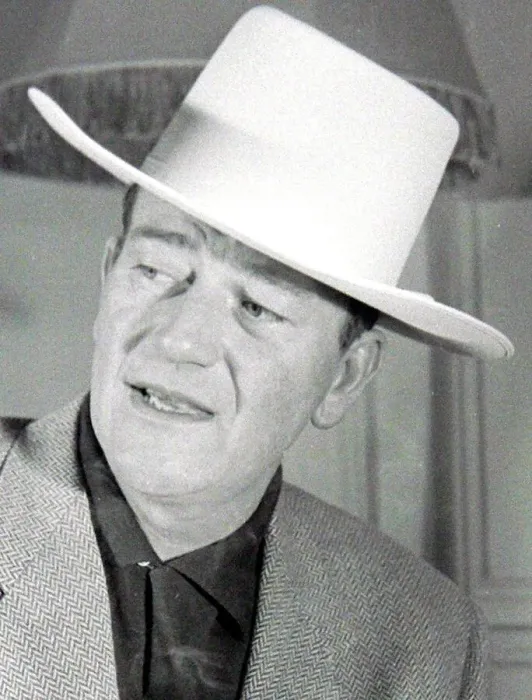 Framed Print : John Wayne, American film actor, arrives in London for the opening of his film