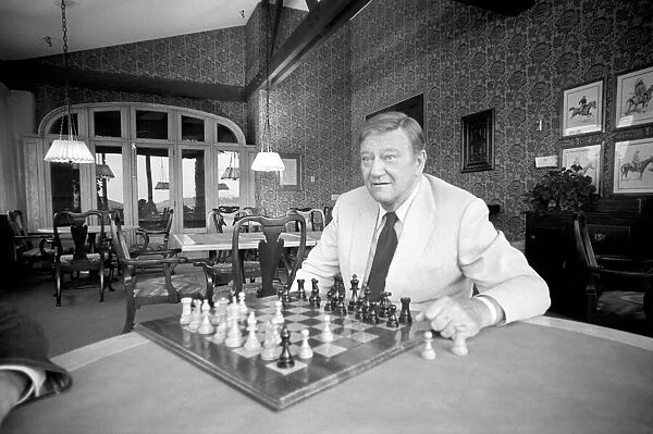 John Wayne who recently starred in Brannigan at home in Texas playing a game of