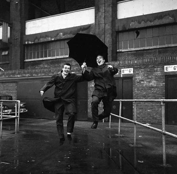 Johnny Byrne and Bobby Moore December 1963 of West Ham United pictured jumping a puddle