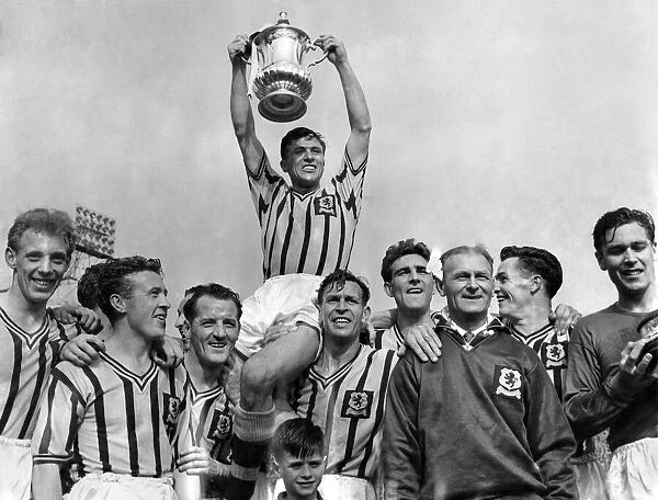 Johnny Dixon the Aston Villa Captain is chaired by team-mates after he has received the F