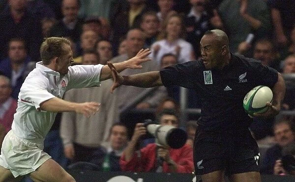 Jonah Lomu of New Zealand Oct 1999 hands off Matt Dawson of England on his way to