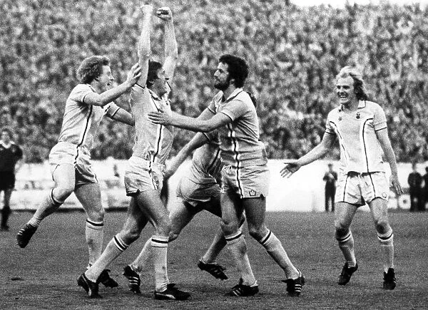 The joy of scoring... Tommy Hutchison, arms held high, is mobbed by delighted City