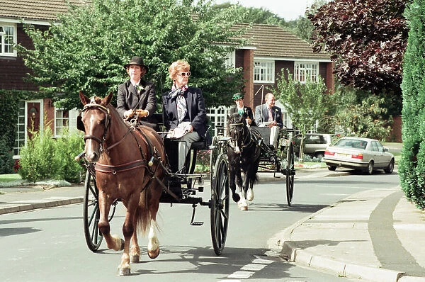 Judges in horse-drawn carriages view the village of Hartlebury, Worcestershire