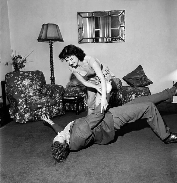 Judo Girl throwing her husband over her shoulder in her living room