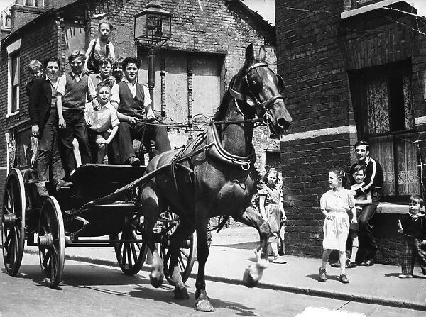 June 1957. Children riding on a cart drawn by a horse which was owned by Griffin