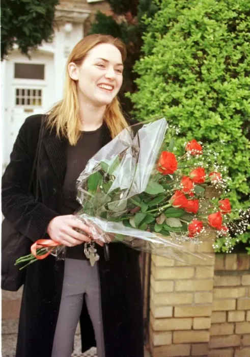 Framed Print : Kate Winslet holding bouquet of flowers outside her home as she told of her love for film