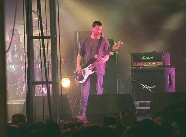 Keanu Reeves actor and musician guitarist with pop group Dogstar playing guitar on stage