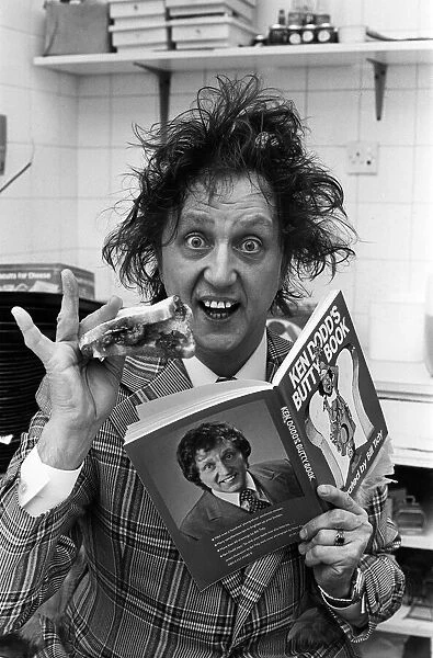 Ken Dodd with a jam butty and the butty book. 15th October 1977