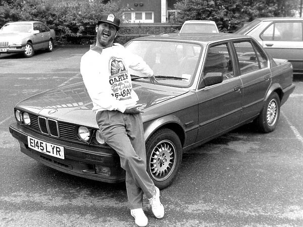 Kenny Everett sitting on bonnet of his new BMW car 21  /  07  /  1989