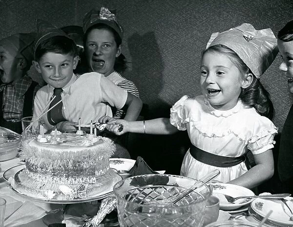Kids pull crackers at Christmas party 1950 Infront of xmas cake