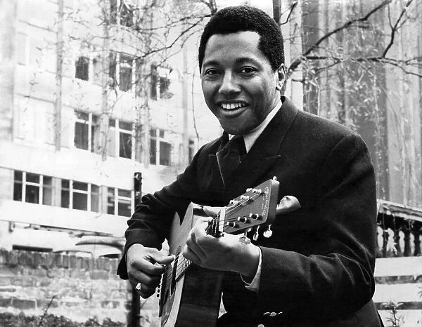 Labi Siffre with his guitar in a City Garden. May 1970 P005510