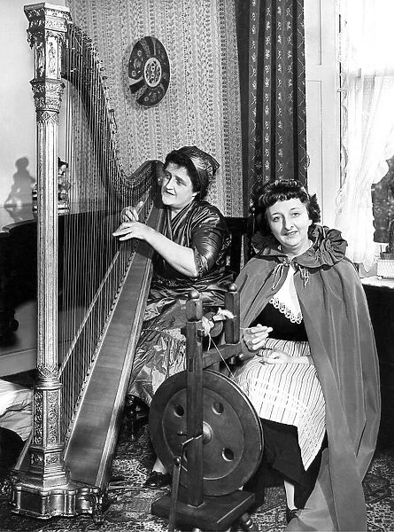 One lady playing the harp while her friend is spinning in April 1960