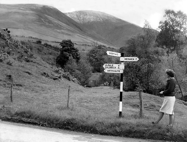 Lake District - A sign post points a woman in the right direction near Orthwaite 1 May