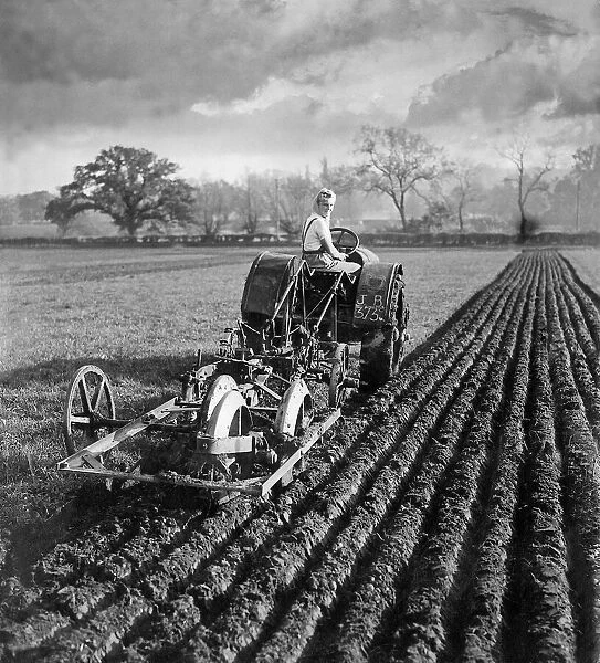 Land girl plowing field with tractor in Berkshire. November 1940