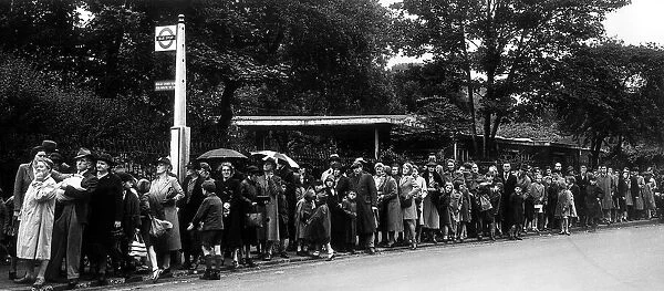 A large queue builds up at a bus stop - August 1942