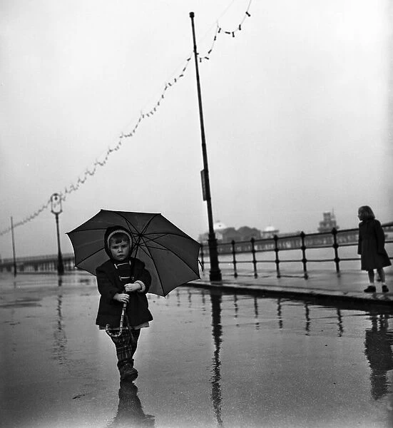 Under a large umbrella is two year old Margaret Curry of Aston, Preston