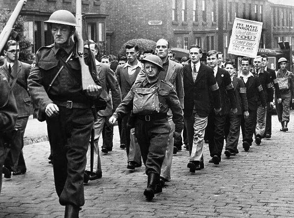 The latest recruits carry a poster in a march of the 77th Lancashire (Bootle