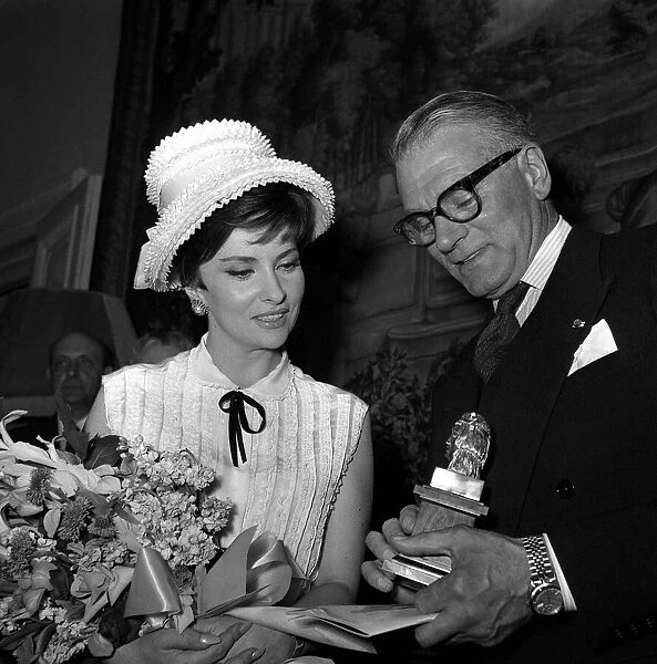 Laurence Olivier Actor May 1963 shows off his Olympus award to actress model Gina