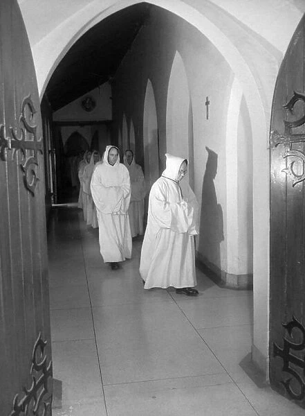 Led by the Abbot, the Rt. Rev. Dom Malachy Brasil, monks file among the silent cloister