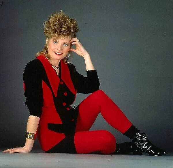 Lee Hepburn actress February 1991. Sitting on floor black red outfit earrings