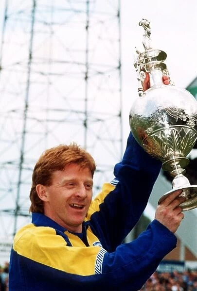 Leeds United footballer Gordon Strachan holds up the league division championship trophy