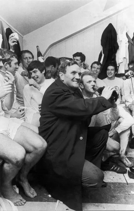 Framed Print : Leeds United manager Don Revie holds a bottle of champagne for captain Billy Bremner Framed Print : Leeds United manager Don Revie holds a bottle of champagne for captain Billy Bremner