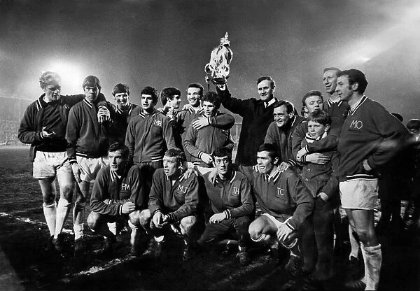 Leeds United manager Don Revie proudly holds the League Championship Trophy surrounded by