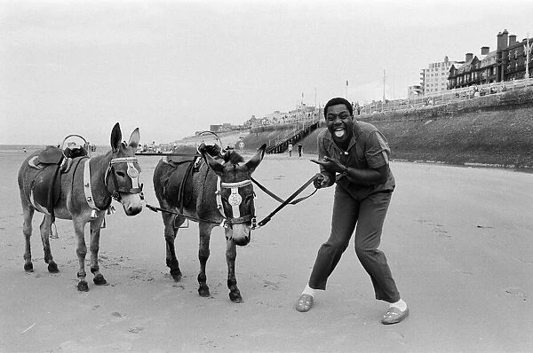 Lenny Henry riding a Donkey at Blackpool Beach, Lancashire. 15th July 1984
