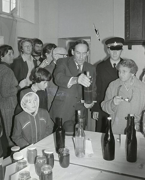Liberal Party leader Jeremy Thorpe looking at bottles as he visits a flower show