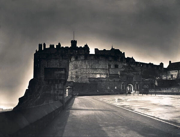 The light from Princes Street forms a halo around Edinburgh Castle as dusk falls