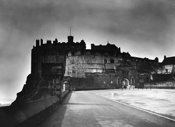 The light from Princes Street forms a halo around Edinburgh Castle as dusk falls