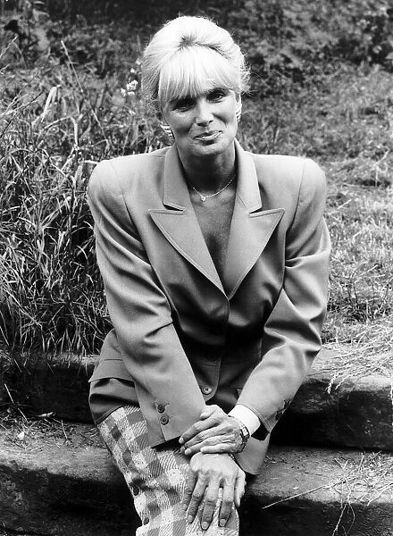 Linda Evans American Actress of Dynasty fame sitting on concrete steps in garden
