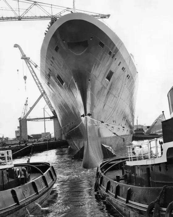 Framed Print : The Liner Queen Elizabeth II, towering over the tugs as she moves into the fitting out Framed Print : The Liner Queen Elizabeth II, towering over the tugs as she moves into the fitting out