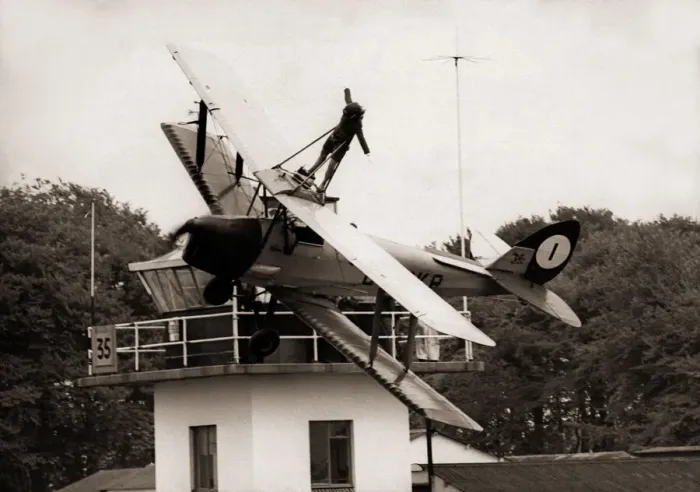 Framed Print : Lisa Winder 24 stands on top of a Tiger Moth Plane as it flys past the watch tower