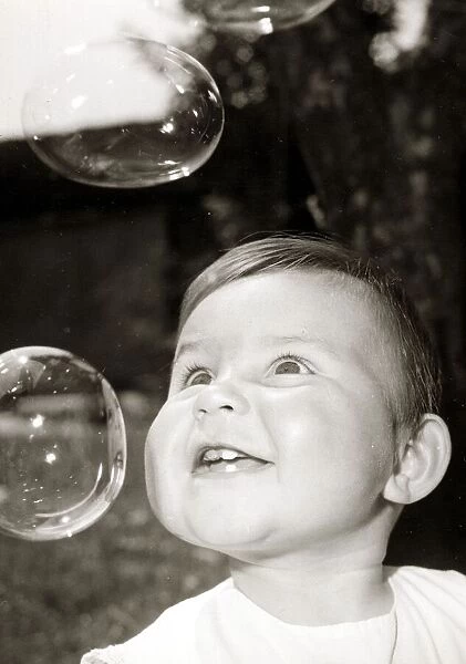 Little boy blowing bubbles, circa 1950