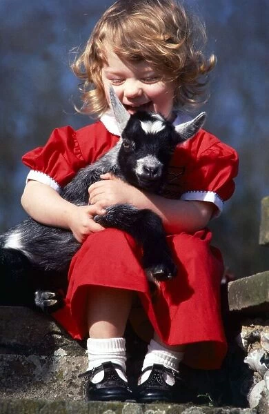Little girl Candida hugging goat kid April 1981