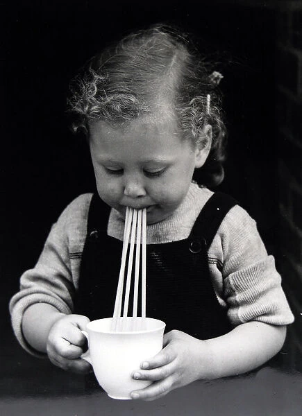 Little girl drinking with five straws This is a low res scan