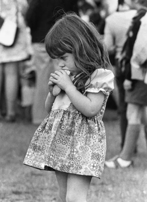 Framed Print : This little girl is enjoying her hot dog more than the occassion