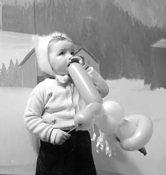 Framed Print : A little girl in a Manchester department store plays with her balloon after seeing Father
