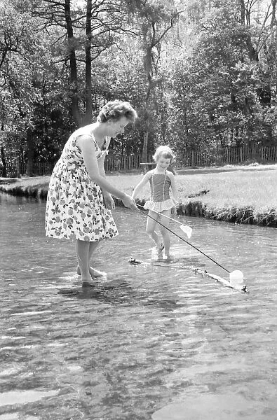 A little girl splashes away with her mother in a stream just inside the main gate of