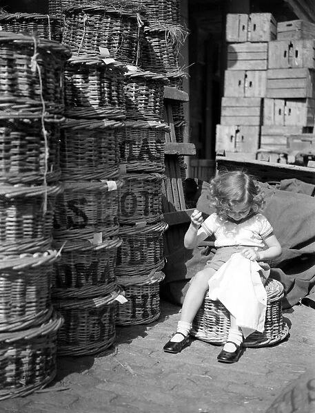 Little girl stitching her dress August 1941 Needle Work sewing basket