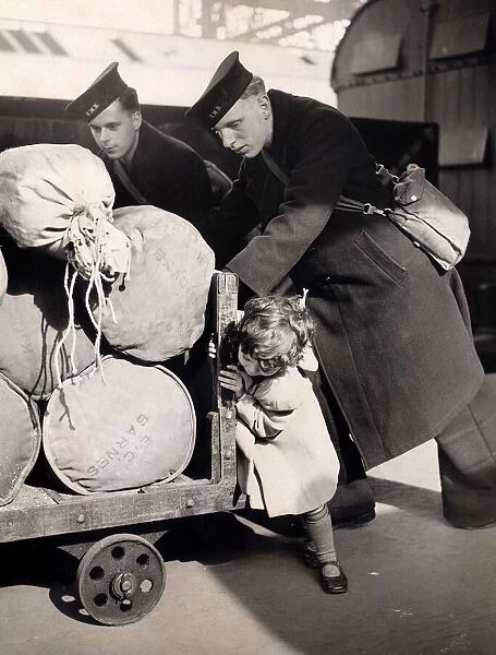 Little Jean Butcher age 3 gives two sailors a hand to push the barrow containing their