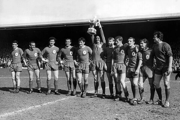 Liverpool captain Ron Yeats holds aloft a mock League Championship trophy for the crowd
