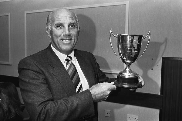 Liverpool coach Ronnie Moran holds the Dixie Dean Memorial trophy after nearly forty