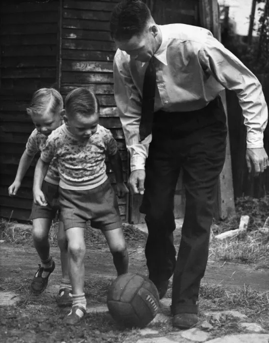 Framed Print : Liverpool footballer Billy Liddell playing football with his twin boys in the back garden Framed Print : Liverpool footballer Billy Liddell playing football with his twin boys in the back garden