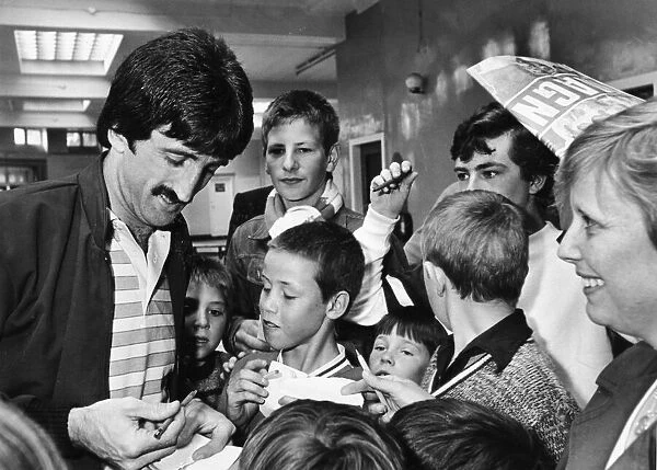 Liverpool footballer David Johnson signing autographs for young fans as the team arrive