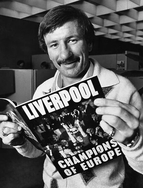 Liverpool footballer Tommy Smith reading a review of Liverpool